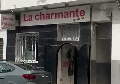 La façade de La charmante, avec son enseigne rouge et sa porte en arche