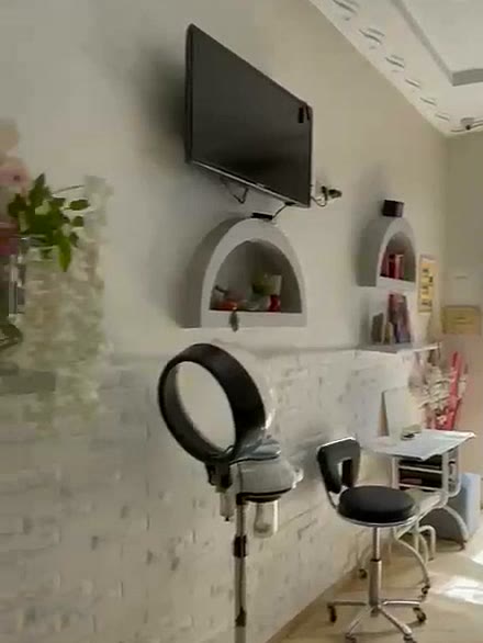 Le côté coiffure du salon : mur de briques blanches, niches en arche et casque séchoir
